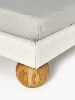 Cama tapizada con patas esféricas de madera Rena