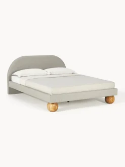 Cama tapizada con patas esfericas de madera Rena