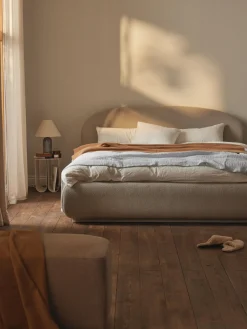 Cama tapizada redondeada en tejido bouclé Alba