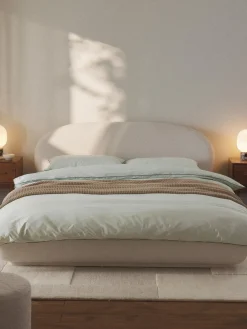 Cama tapizada redondeada en tejido bouclé Alba